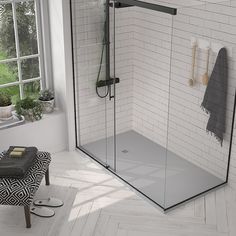 a bathroom with a walk in shower next to a white tiled wall and flooring