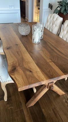 a wooden table with white chairs around it