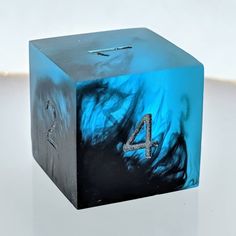 a blue cube with the number four painted on it's side and water swirling around it