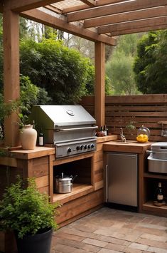 an outdoor kitchen with stainless steel appliances and wooden decking, surrounded by greenery