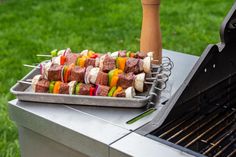 an outdoor grill with several skewers of food on it