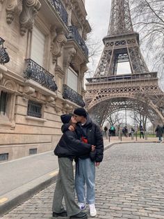 two people standing in front of the eiffel tower