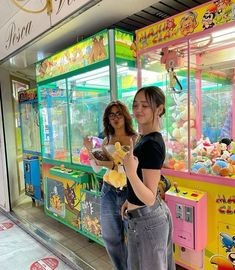 two women standing in front of a toy store