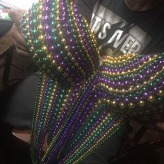 a man is sitting down with some beads on his arm