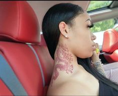 a woman with tattoos on her neck sitting in a car