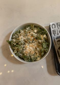 a bowl of food sitting on top of a table next to a fork and napkin