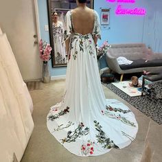 the back of a woman's wedding dress is shown in front of a mirror