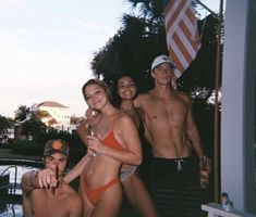 a group of people standing next to each other in front of a pool with an american flag on it