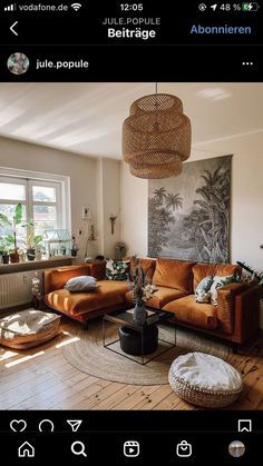 a living room filled with furniture and a large painting on the wall above it's windows