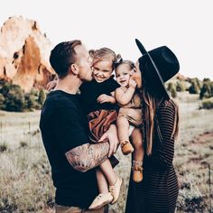 a man and woman are holding two small children