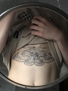 a close up of a person with a butterfly tattoo on their stomach