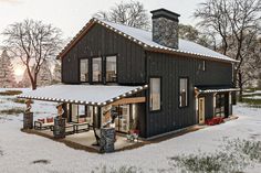 a black house with snow on the ground