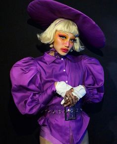 a woman in a purple outfit and hat