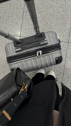 a person standing with their feet on luggage