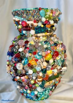 a vase filled with lots of different colored beads