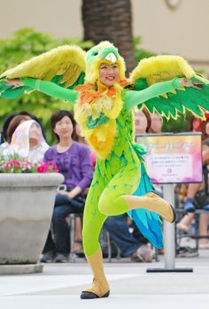 a woman dressed in green and yellow dancing