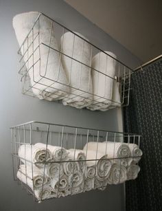 two metal baskets holding towels and folded towels