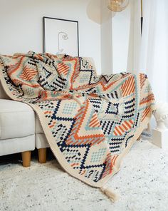 a living room with a couch and blanket on the floor