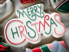 decorated cookies with merry christmas written on them and holiday decorations around the edges in green, red, and white