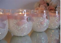 there are many wine glasses that have pink bows and glitters on them, all lined up in a row