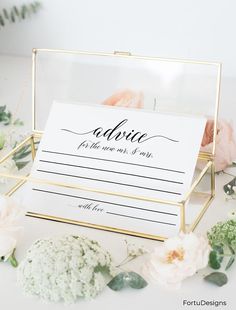 an acrylic sign is sitting on a table with flowers and greenery around it