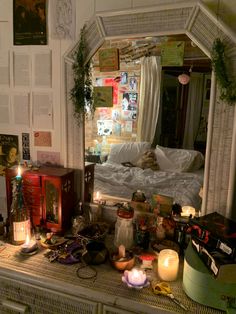 a mirror sitting on top of a dresser filled with clutter and candles in front of it