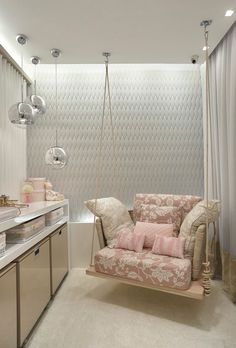 a living room filled with furniture next to a sink and counter top under hanging lights