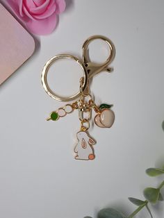 a close up of a keychain on a table with flowers in the background