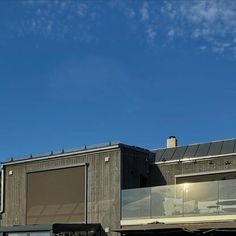 an airplane is flying in the sky over a building with glass balconies on top