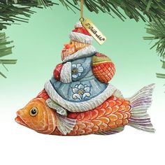 a christmas ornament hanging from a tree with a fish on it's back