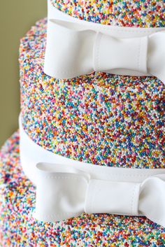 three tiered cake with sprinkles and bows