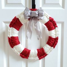 a red, white and gray wreath hanging on a door