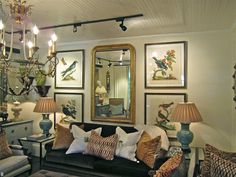 a living room with couches, lamps and pictures hanging on the wall above them