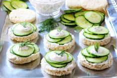 cucumber sandwiches with cream cheese and dill sprinkles on a tray