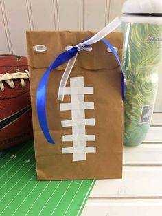 a brown paper bag with a football on it and a blue ribbon around the handle