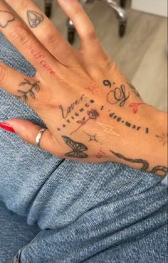 a woman's hand with tattoos on it and writing on the wrist is shown