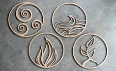 four circular cutouts with leaves and swirls in them on a gray surface,