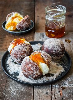 powdered sugar covered pastries on a black plate