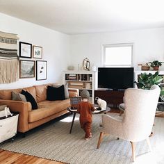 a living room filled with furniture and a baby standing in front of the couches