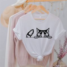 As a Serenad Craft proudly announce our new t -shirts. These are best quality t - shirts and designs. Cat Shirt, Cat Face Shirt, Gift for Cat Lover, Cat Mom Shirt, Cat Shirts for Women, Cat Owner Gift Idea, Cute Cat Shirt, Kitty Shirt&SIZE• Please check size chart before order• Our t-shirts are unisex• If ladies more fit, please order one size down.&CARET-shirts are made of 100% combed ring spun cotton and 4.2 oz.Just wash inside out warm and no iron on decoration. Do not bleach do not d White Short Sleeve Shirt With Cat Print, White Crew Neck Top With Cat Design, White Crew Neck Shirt With Cat Print, White Casual Shirt With Cat Print, White Cotton Shirt With Cat Design, Feyonce Shirt, Cat Shirts For Women, Nyc Shirt, Cat Tee Shirts