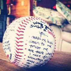 a baseball sitting on top of a wooden table in front of a couch with writing on it