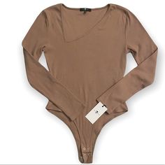 a women's long sleeved bodysuit with a tag on the chestline