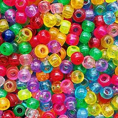 there are many different colored beads on the table and in the background is a large pile