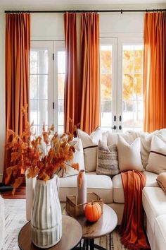 a living room filled with furniture and orange drapes