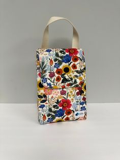 a flowered bag is sitting on a white surface