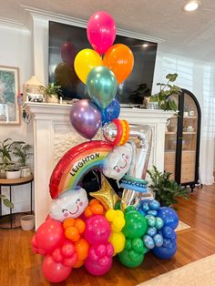 a bunch of balloons that are sitting on the floor in front of a fireplace and television