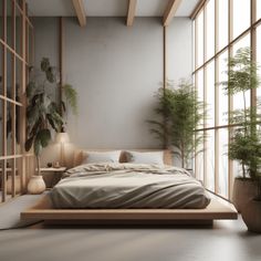 a large bed sitting in the middle of a room next to tall windows and potted plants