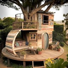 a tree house built into the side of a wooden structure with stairs leading up to it