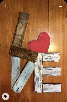 the word love is made out of wooden planks and painted with red heart on top