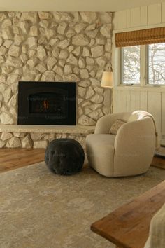 a living room with a large stone fireplace